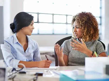 Duas profissionais conversando em um espaço de trabalho